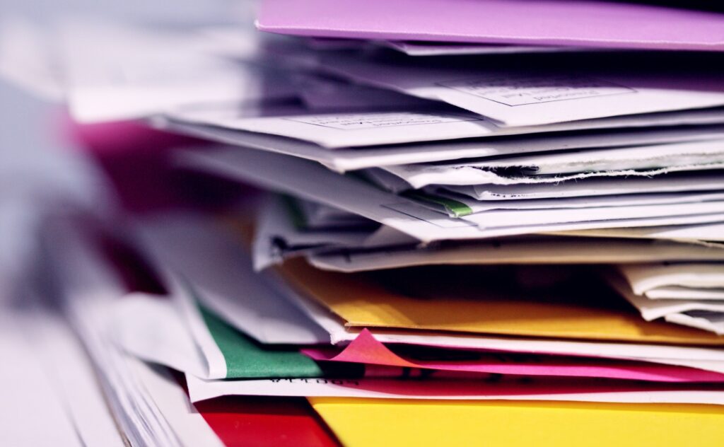 A stack of utility bills, bank statements and other documents that could be used as proof of address in the UK.